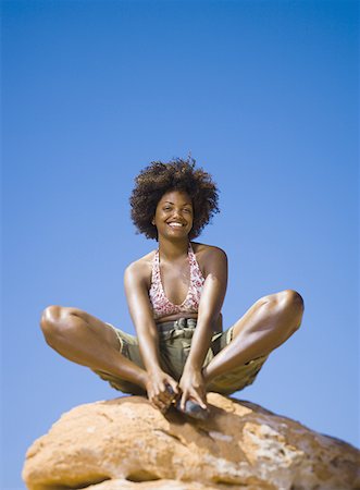 simsearch:640-01358229,k - Low angle view of a young woman sitting on a rock Stock Photo - Premium Royalty-Free, Code: 640-01364523