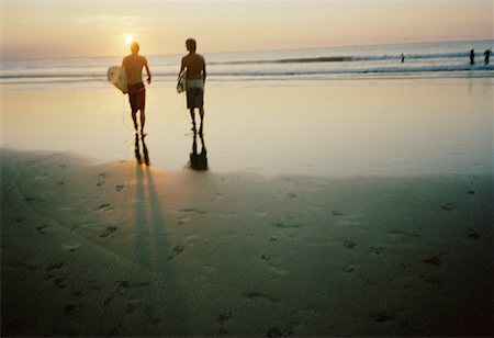 silhouette walking with surfboard - Rear view of two surfers walking on the beach Stock Photo - Premium Royalty-Free, Code: 640-01364592