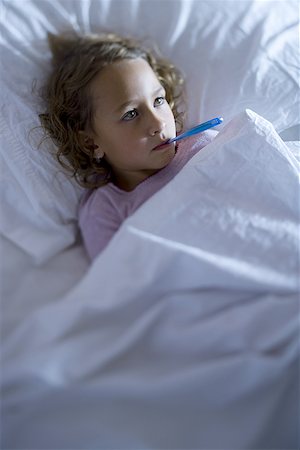 High angle view of a girl in a bed with a thermometer in her mouth Stock Photo - Premium Royalty-Free, Code: 640-01364877