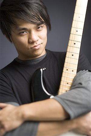 simsearch:640-01365707,k - Portrait of a young man holding an electric guitar Stock Photo - Premium Royalty-Free, Code: 640-01364873