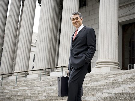 simsearch:640-01351636,k - Low angle view of a male lawyer standing on the steps of a courthouse and smiling Stock Photo - Premium Royalty-Free, Code: 640-01364886