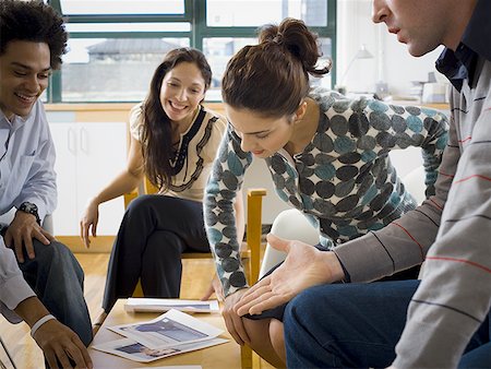 Four people discussing ad layouts Stock Photo - Premium Royalty-Free, Code: 640-01365063