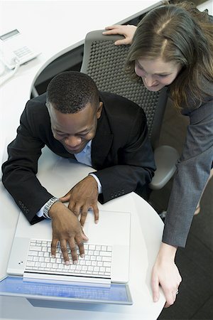 High angle view of a businesswoman and a businessman using a laptop Stock Photo - Premium Royalty-Free, Code: 640-01365164