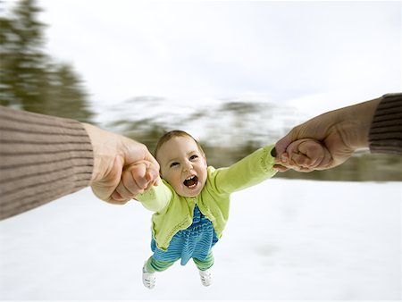 Mother swinging child outdoors in winter Stock Photo - Premium Royalty-Free, Code: 640-01365333