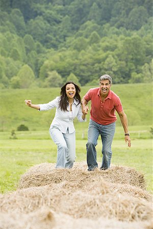 simsearch:640-01356213,k - Portrait of a man and a woman running on hay bales Stock Photo - Premium Royalty-Free, Code: 640-01365492