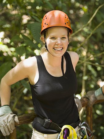 Portrait of a young woman wearing climbing gear and smiling Stock Photo - Premium Royalty-Free, Code: 640-01365528