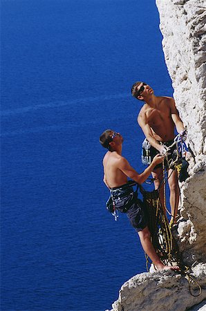 Two men climbing mountain with harnesses and ropes Stock Photo - Premium Royalty-Free, Code: 640-01365599