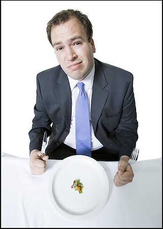 simsearch:640-01350815,k - High angle view of a young man sitting at the dining table and holding a fork Stock Photo - Premium Royalty-Free, Code: 640-01365747