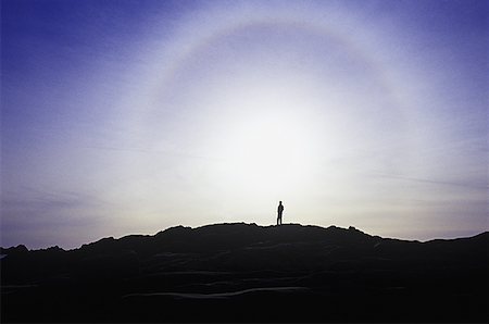 A silhouette of a person standing on top of a mountain Stock Photo - Premium Royalty-Free, Code: 640-01365835