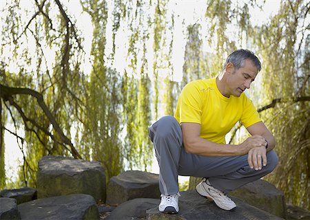 Low angle view of a mature man looking at his wristwatch Stock Photo - Premium Royalty-Free, Code: 640-01365846