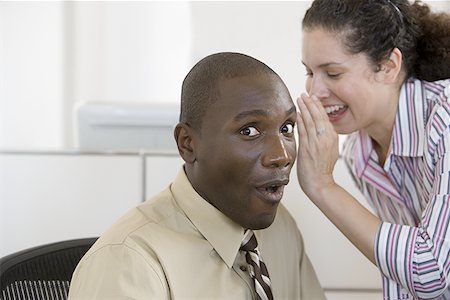 Businesswoman whispering in businessman's ear Stock Photo - Premium Royalty-Free, Code: 640-01365903