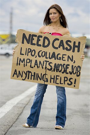 Woman standing on side of road soliciting cash Stock Photo - Premium Royalty-Free, Code: 640-01365941