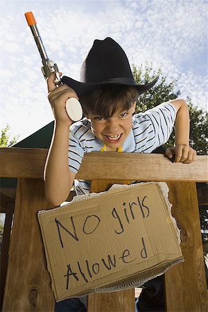 Low angle view of a boy dressed as a cowboy Stock Photo - Premium Royalty-Free, Code: 640-01366370