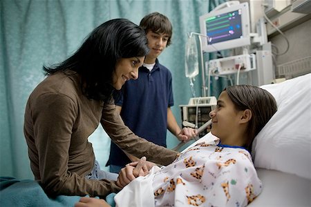 Profile of a mother and son visiting a girl in the hospital Stock Photo - Premium Royalty-Free, Code: 640-01360092