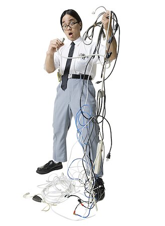 simsearch:640-01350815,k - Young man holding a bundle of tangled extension cords Stock Photo - Premium Royalty-Free, Code: 640-01360105