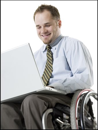 radius - Close-up of a young man sitting in a wheelchair using a laptop Stock Photo - Premium Royalty-Free, Code: 640-01360107