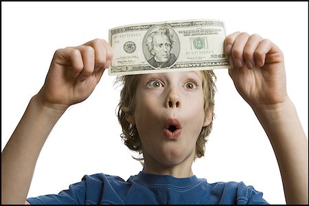 Close-up of a boy looking at a twenty dollar bill Stock Photo - Premium Royalty-Free, Code: 640-01360129