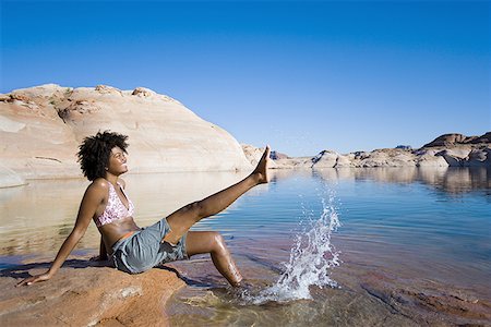 simsearch:640-01358229,k - Profile of a young woman sitting on a rock and splashing water Stock Photo - Premium Royalty-Free, Code: 640-01360135