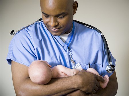 Male nurse or doctor holding newborn baby Stock Photo - Premium Royalty-Free, Code: 640-01360509