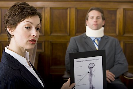 simsearch:640-01351636,k - A female lawyer pointing at evidence in front of a victim in a courtroom Stock Photo - Premium Royalty-Free, Code: 640-01360717