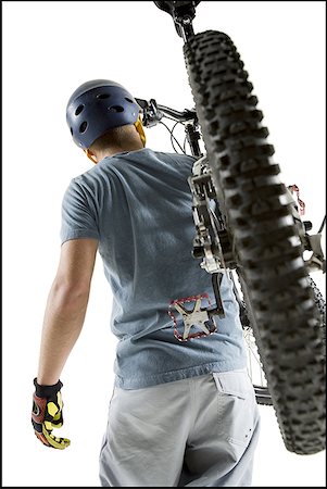 silhouette bike - Rear view of a young man carrying a bicycle on his shoulder Stock Photo - Premium Royalty-Free, Code: 640-01360780