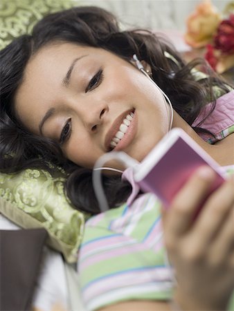 Close-up of a teenage girl holding an MP3 player Stock Photo - Premium Royalty-Free, Code: 640-01361062