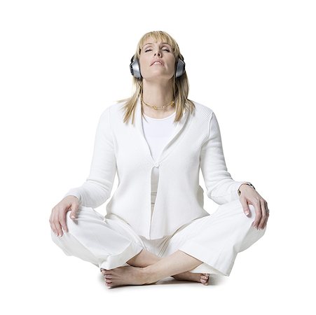 simsearch:640-03265635,k - Mid adult woman meditating on the floor wearing headphones Stock Photo - Premium Royalty-Free, Code: 640-01361267