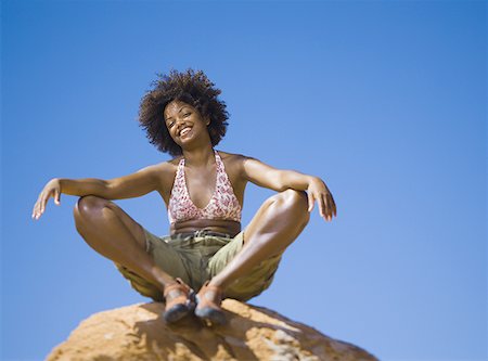 simsearch:640-01358229,k - Low angle view of a young woman sitting on a rock Stock Photo - Premium Royalty-Free, Code: 640-01361564