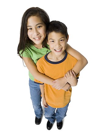 simsearch:640-03263432,k - Portrait of a sister hugging her brother from back and smiling Stock Photo - Premium Royalty-Free, Code: 640-01361683