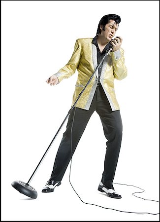 funny dance pose - An Elvis impersonator singing into a microphone Stock Photo - Premium Royalty-Free, Code: 640-01361699
