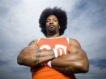 Basketball player with an afro in orange uniform Stock Photo - Premium Royalty-Free, Code: 640-01361972