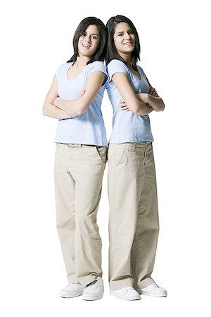 Portrait of two teenage girls standing back to back Stock Photo - Premium Royalty-Free, Code: 640-01361987