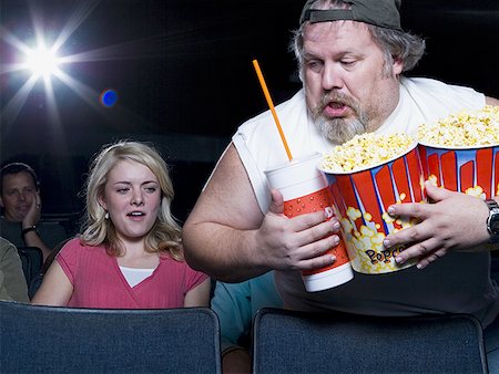 simsearch:640-02773406,k - Large man with buckets of popcorn and drink at movie theater Stock Photo - Premium Royalty-Free, Code: 640-01362118