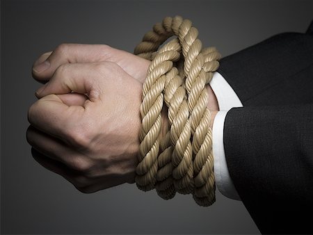 Close-up of a man's hands tied together with rope Stock Photo - Premium Royalty-Free, Code: 640-01362368