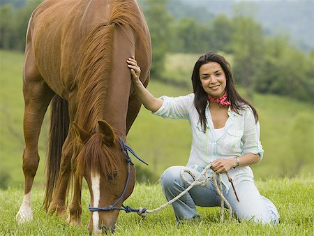 Portrait of a woman holding the reins of a horse Stock Photo - Premium Royalty-Free, Code: 640-01362534