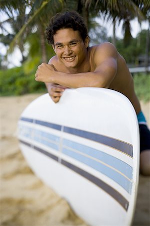 surfboard close up - Portrait of a young man smiling and leaning against a surfboard Stock Photo - Premium Royalty-Free, Code: 640-01362863