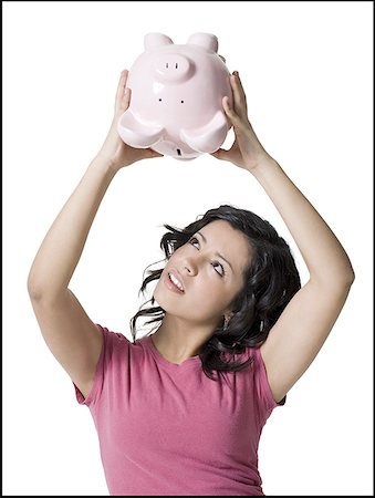 A girl shaking a piggy bank upside down Stock Photo - Premium Royalty-Free, Code: 640-01362953