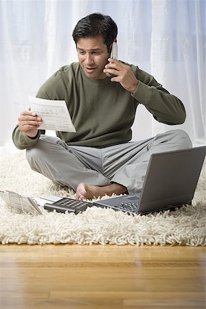 shag carpet - Man sitting on the floor at home, working and talking on a phone Stock Photo - Premium Royalty-Free, Code: 640-01362987