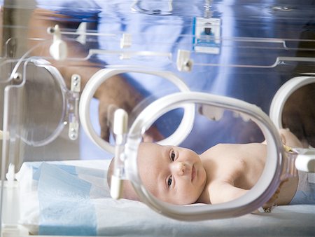 Baby in incubator with man in uniform Stock Photo - Premium Royalty-Free, Code: 640-01363042