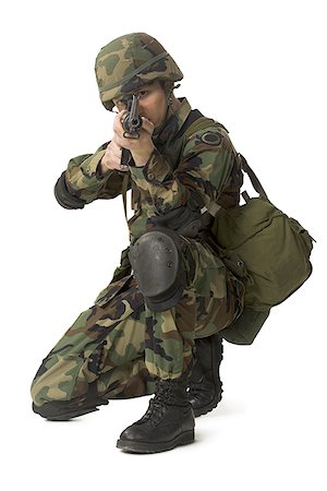 Portrait of a soldier crouching and aiming his rifle Stock Photo - Premium Royalty-Free, Code: 640-01363248