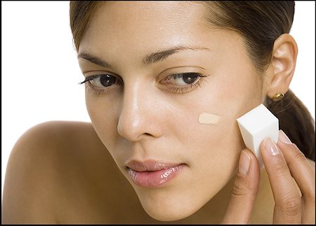 Close-up of a woman applying liquid makeup Stock Photo - Premium Royalty-Free, Code: 640-01363286