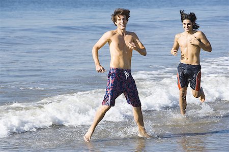 Two young men running on the beach Stock Photo - Premium Royalty-Free, Code: 640-01363369