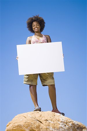 simsearch:640-01358229,k - Low angle view of a young woman holding a blank sign Stock Photo - Premium Royalty-Free, Code: 640-01363564