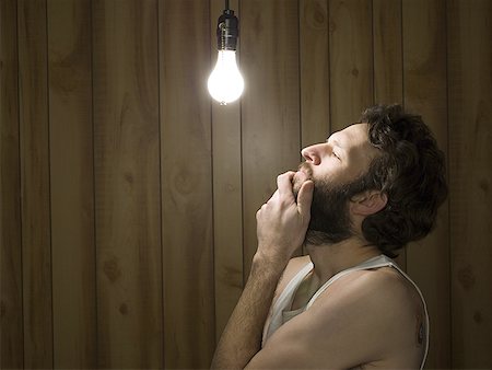 simsearch:640-01362739,k - Man looking thoughtfully at light bulb Stock Photo - Premium Royalty-Free, Code: 640-01363595