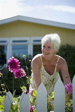 pictures of house with picket fence - Close-up of a mature woman gardening and smiling Stock Photo - Premium Royalty-Free, Code: 640-01363823