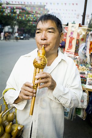 Man playing a Chinese woodwind instrument Stock Photo - Premium Royalty-Free, Code: 640-01363914