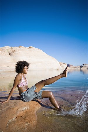 simsearch:640-01358229,k - Profile of a young woman sitting on a rock and splashing water Stock Photo - Premium Royalty-Free, Code: 640-01363935
