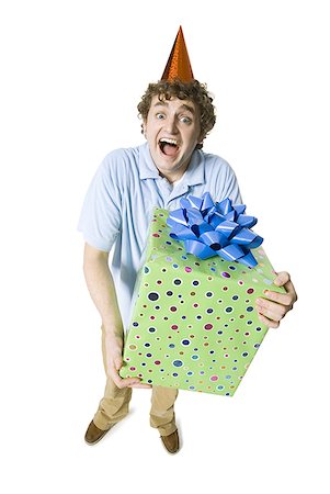 simsearch:673-03826592,k - Man with party hat holding gift box smiling Stock Photo - Premium Royalty-Free, Code: 640-01458504