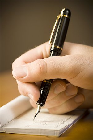 fountain pen - Detailed view of man holding fountain pen and endorsing check Stock Photo - Premium Royalty-Free, Code: 640-01458522