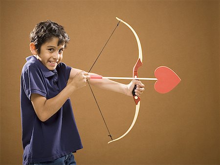 Boy with bow and arrow with heart on it Stock Photo - Premium Royalty-Free, Code: 640-01574908